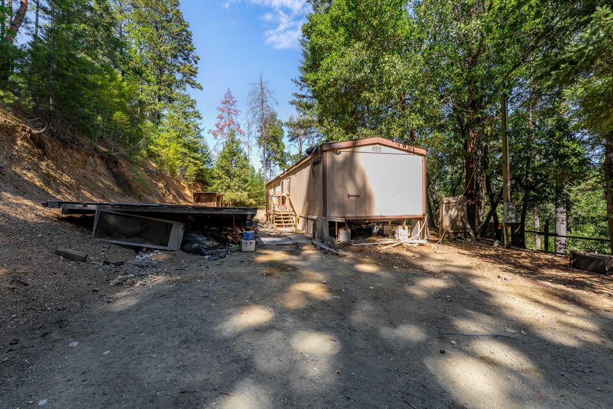 Unlock the possibilities with this private 5-acre retreat! Tucked away down a quiet country road, this 2-bedroom, 2-bath home offers a great opportunity for those with vision. Surrounded by nature and full of potential, it's ready for someone to bring it back to life. A peaceful setting, a great price, and endless room to create your dream, this property is being sold as-is and will require cash or seller is offering an owner carry option. Bring your ideas and make it yours! The septic tank was pumped 7/20/25, report on file.