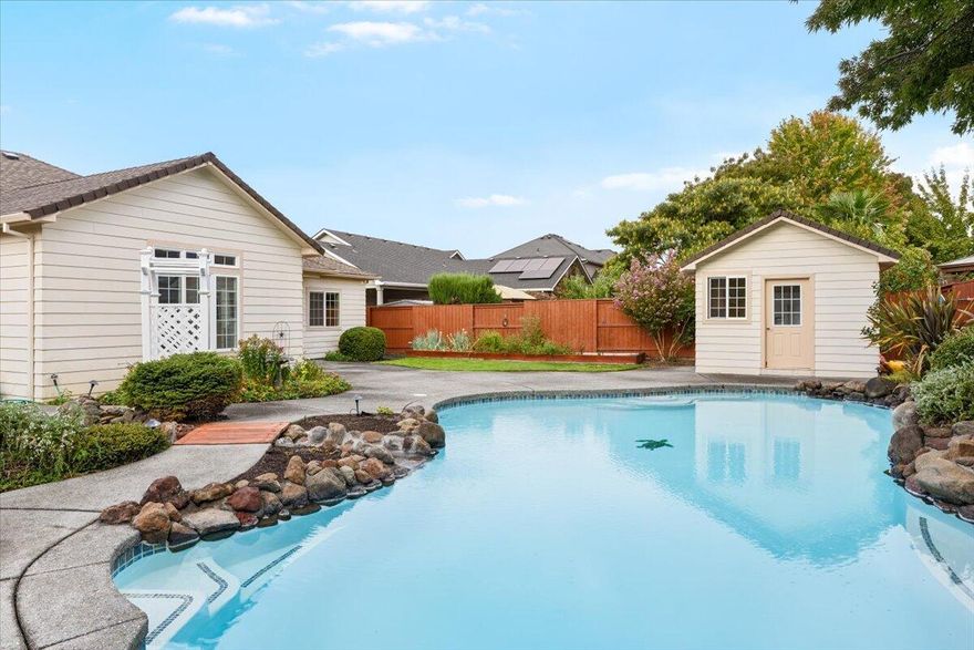 Resort backyard with a LARGE in-ground, heated pool + attached in-ground hot tub—moments from Don Jones Memorial Park. This single-level 3BR/2.5BA flows effortlessly for everyday living and entertaining: a vaulted great room anchored by a gas fireplace with custom mantel, a granite/stainless kitchen with extensive cabinetry and breakfast bar, and French doors that open to the pool deck. A tray-ceiling flex room works as dining or office. Split bedroom layout for privacy. The spacious primary suite offers patio access, dual sinks, a soaker tub, a tiled walk-in shower with dual shower heads, and a huge walk-in closet. Outside is your stay-cation: lagoon-style pool with rock accents and water feature, integrated hot tub beside the arbor walkway, mature landscaping, and a pool house with its own half-bath—perfect for guests, changing, or hobbies. Dedicated laundry with sink/storage and a 2-car garage. Close to parks, schools, and conveniences!