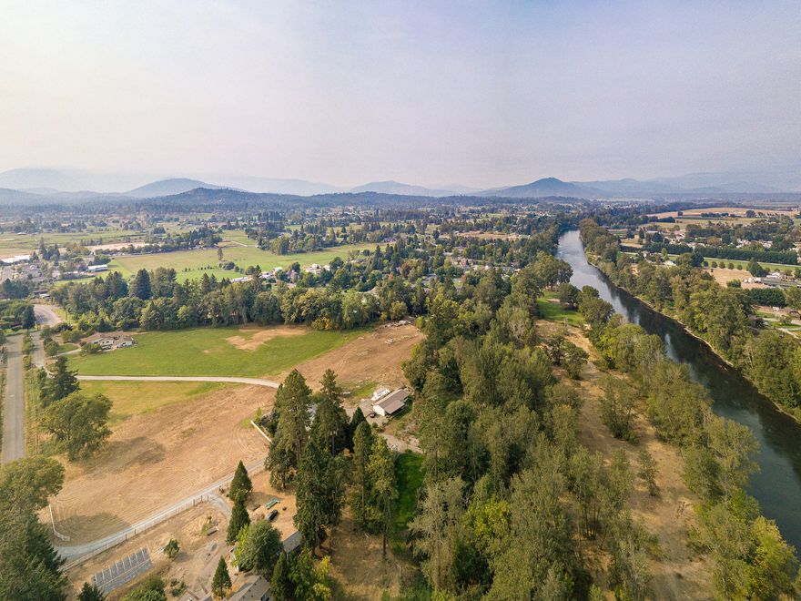 Escape and relax on this breathtaking 15+ acre private riverfront oasis. This stunning estate is situated on the banks of the extraordinary Rogue River and boasts approx. 502ft of prime river frontage, awaiting your enjoyment. Fully equipped w/ city sewer, well+ irrigation, sprinklers, GPID canal, natural gas, RV hookups, low county taxes & a year round creek. 30,000sf of sweeping park-like grounds, a covered gazebo, overhead lighting and 2 natural springs- imagine breathtaking private weddings + events! Main homesite is a picture perfect Farmhouse w/ approx. 1817sf + a full finished basement. 1bed/1bath guest cottage, would make the sweetest Airbnb, each w/ a private yard + unbeatable views of this rare estate. Your restful ambiance awaits you! Largest zoned RR-1 river property left in district 7, for an abundance of untapped development potential- including the potential for several buildable riverfront + river access lots. Live, rent, vacation, or develop- Vast opportunity awaits!