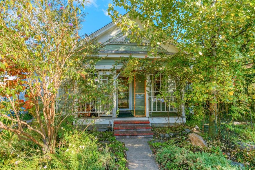 Darling Railroad District cottage on beautiful deep lot with alley access. Large aspen tree in front canopies the sweet covered front porch that leads to charming interior with open living & dining room, 2 bedrooms, 1 bath, screened in porch & laundry room. Loads of charm with fir floors, crown molding, 10' ceilings. Bead board in the master bedroom adds to the character throughout this home. Large bathroom with tile flooring & claw foot tub. The screened in sun porch is spacious, opens to the covered rear porch & overlooks the wonderful rear yard. The yard is all organic & perma-culture, fully on drip, has 5 planter beds, berries, birch trees, clematis, 3 apple trees, vintage roses & more. Brick pathways lead to English garden, wild plum, cosmos, artichoke & composting bin. 385 gallon water storage & collection system & there is even an artesian well! Rear detached garage with loft & separate room. Newer good sized cedar storage shed & one car off street parking if desired.