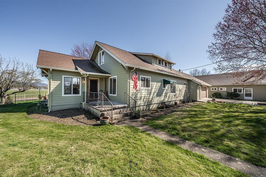 This spectacular level 21.24 acre irrigated property, located in the heart of Grants Pass, has a wonderful 2 story farmhouse with basement, caretaker residence, large 38 x 72' barn w/metal metal roof, 8 stalls w/railroad tie floors, tack room, laundry /storage & hay storage, 36x48' Noble 8 stall barn, wash rack, 100 x110' arena, 120' round pen, Large equipment/hay/shaving storage building, year round pond, fenced and cross fenced irrigated pastures. A comfortable 4 bedroom, 2 bath home features a large living room,
den with glass doors, dining room with French doors to an expansive deck, bright country kitchen, guest bedroom, bathroom and laundry room. Upstairs are the additional bedrooms with full bathroom. Basement offers space for your hobbies, shop& storage! This ranch has been a cattle ranch, home & training facility for cutting & roping horses, goats, chickens, dogs, a family home & recreational haven. This amazing
established ranch is ideal for family, retreats, and more!