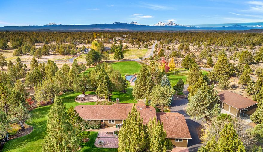 The Cascade Mountains overlook this true estate property just minutes from Bend. A cascading water feature empties into a bridged pond serving as the foreground view for this single level totally renovated home. Spacious open floor plan exhibiting northwest elegance with truly gourmet kitchen that is a chef's dream. Private primary bedroom looks out upon the Cascades and the water feature. At the opposite end of the home is another bedroom with private bath. Extensive hardwood flooring, a cozy fireplace in the intimate living room, and a large and inviting vaulted great room offer a multitude of living options. Overall there are 3 garage areas with 8 total garage bays plus RV shop with 1/2 bath and guest quarters or potential office above, abundant space for a car collection or outdoor toys. Gardeners will enjoy the greenhouse and the 'taj mahal' of chicken coops. Finally, a complete wood shop for the hobbyist.