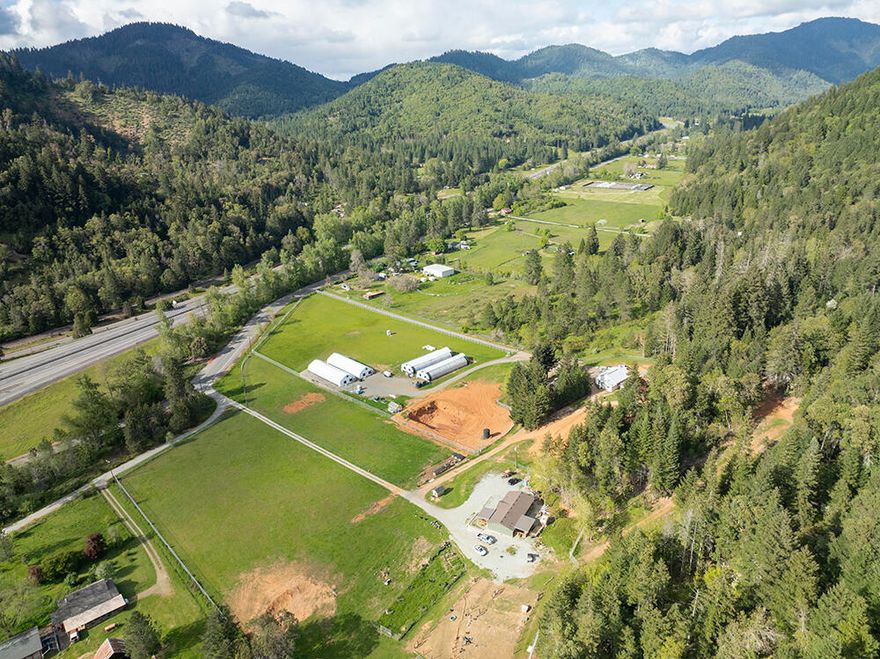 Escape to your own Agricultural Paradise! This 16.34-Acre Pristine Property offers fertile land w/riparian irrigation rights from Wolf Creek—ideal for growing vegetables, fruits, or specialty crops. The 3 bed/2 bath home features updates, skylights, a brand-new roof & serene mountain views. 6 large outbuildings include 4 automated climate-controlled greenhouses totaling 13,300sf, each equipped w/LED Gavita 1000W HPS lights, Quest humidifiers, fans, roll-up blackout sides, and 2 feature radiant heat concrete floors—perfect for year-round cultivation. A 2280sf Warehouse includes Roll-Up Doors, Multiple Indoor Grow Rooms, 36 Cameras in Security System & Walk-in Freezer, Tool Room, Office & more. Huge 2-story Newer Bunkhouse has fresh exterior paint & features huge ''bunk rooms,'' 2 bathrooms, laundry facilities & more. Don't miss the fenced pasture, huge pond, 3-Phase Power & smaller greenhouse. If you are dreaming of a self-sustaining lifestyle, this turnkey farm is ready for you!