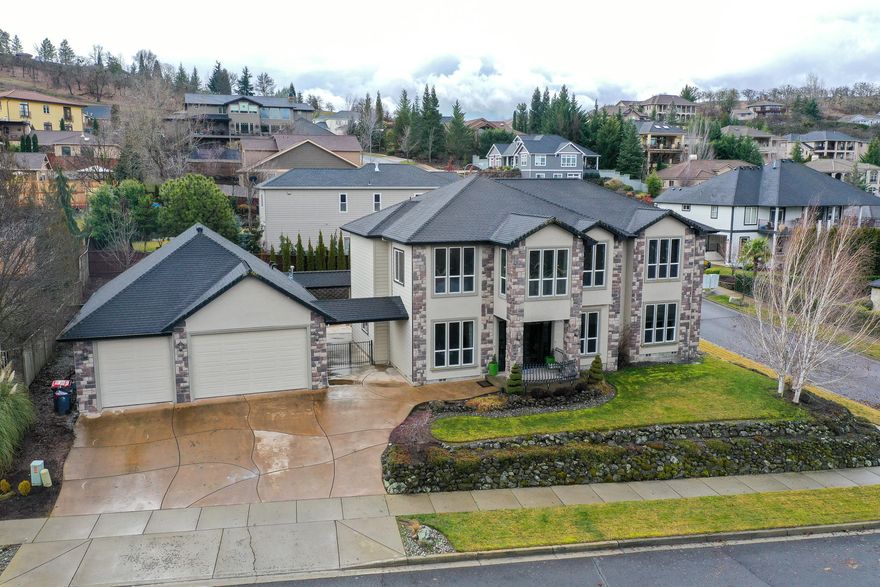 This spectacular 4,052SF home features 5 bedrooms, 2.5 bathrooms, a HUGE 6-car garage and a media room with separate wet bar! Large main floor master suite. Bright and open gourmet kitchen with granite counters, tile floors and beautiful dark cabinetry. Family rooms on each floor with gorgeous gas fireplaces. Home includes a formal dining room, kitchen bar and breakfast nook, as well as an attached loft off one of the upstairs bedrooms. The exterior is highlighted by meticulous landscaping, downstairs patio and upstairs deck over-looking the large, level backyard.