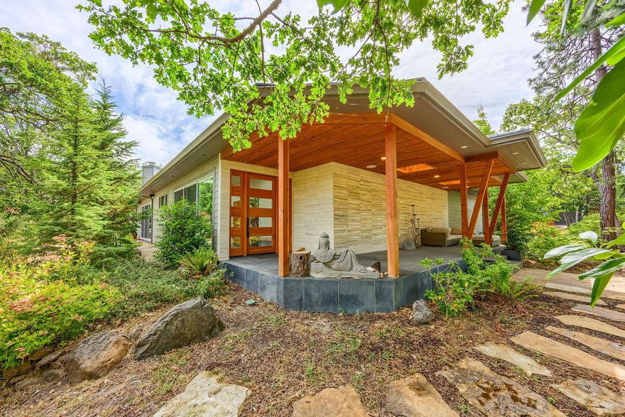 This stunning estate provides a uniquely designed light filled home with the privacy of over 22 acres. The living space revolves around an outdoor courtyard. The extensive use of glass brings in an abundance of natural illumination from all directions. Opening the sliders allows for a flow between the living space and the natural beauty outside. A massive great room provides wonderful space for large gatherings. The recently remodeled chef's kitchen includes a double oven, built in refrigerator / freezer, and a large pantry. Black granite and Caesarstone counters provide a modern look. The wine storage and tasting room are on the lower level. Natural flooring materials include oak, cherry and stone. Each suite provides outdoor access and is complimented by a well-appointed bathroom. There is an attached 3-car garage and a large, detached workshop. This private mountain sanctuary is only minutes from downtown Ashland.