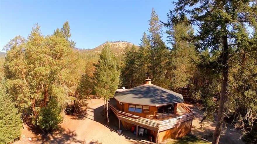 Unique octagon home with room to spread out on this 7+ acre property. In the winter cozy up in the warm living room with knotty pine vaulted ceilings and a wood burning fireplace. In the summer enjoy the deck that wraps around the front of the home and the fire pit located in the front yard area perfect for making s'mores! 3rd bedroom is located downstairs, a huge space with a fireplace that can also be used as a family room or den. Also downstairs is another room that can be used as an office, shop or just for storage. Large open barn for horses or storage. Separate locked detached storage room or 2nd shop. Lots of storage inside and outside. Washer/Dryer and Fridge included. Great property for horses.