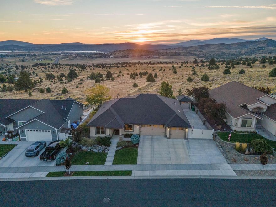 Amazing home! Contemporary style featuring open floor plan located in the prestigious SKYRIDGE SUBDIVISION.   The architecture frames the dramatic unencumbered views of the basin lights and Mt. Shasta.  There is a gate secured area for your large RV/boat and right behind is a standalone hobby shop\storage. The three-car garage floor is finished with Epoxy.  The home is well fenced.  As you begin your journey of this really outstanding home, you will be amazed at the view offered upon entrance and the beauty of the upscale finish work throughout seldom seen in this price range.  Some ceilings are coffered; some with lighting.  The wood floors are very color rich throughout.  You will note the (Two) primary suites one on each side of home.  The larger primary is quite large.  The computer room offers a serene setting with natural light flowing in.  This room could also be used for your 4th bedroom.  Did I mention the truly outstanding fireplace to keep you warm on chilly evenings.