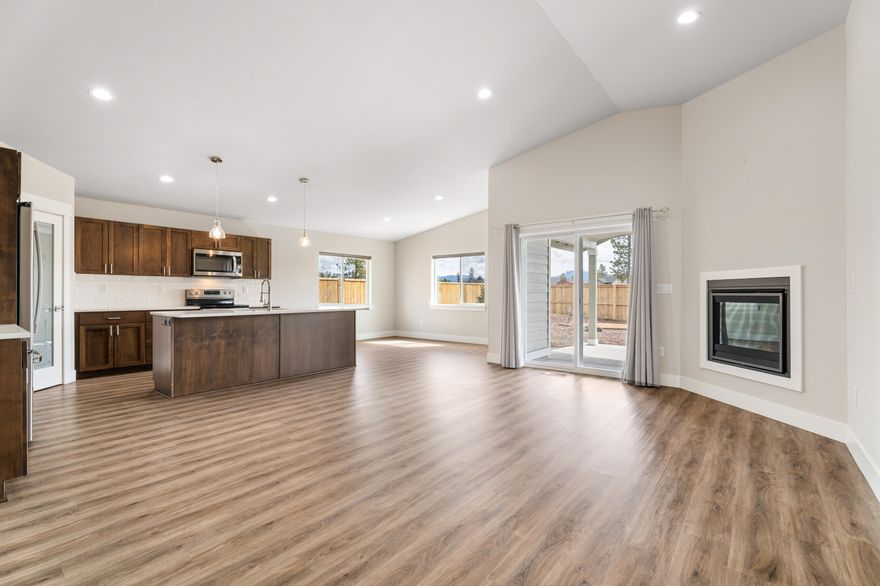 This large .22 acres corner lot is fully fenced and backs up to open space. The 3-4 bedroom home with office has been lightly lived in by it's out of state owners, and it is the one with the builder upgrades! These meticulous owners added A/C, custom blinds on all the windows, it has a 4 zone watering system in front and back with professional landscaping. The gas fireplace in the main living space adds a perfect ambience to enjoy space highlighted by the vaulted ceilings. The chef's kitchen is built around a gorgeous island and an off-set dining room that offers views and access to the back yard with a huge covered porch offering a perfect place for entertaining and relaxing. The Reserve at the Pines is quickly becoming La Pine's sought after neighborhood with its convenient location and very chill vibe. This home is simply bigger and better for so many reasons - it's a must see!!