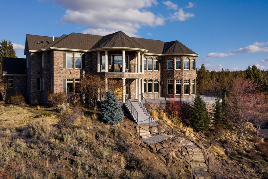 This magnificent home surrounded by 13+ acres has it all! Seven mountain View? Check! Stunning sunsets? Check! Home office? Check! Work out room? Check! Meandering paved drive leads to over 6300 feet of gracious elegance-craftsmanship of the highest quality! Floor to ceiling stone fireplace in great room. Beautiful sunroom upstairs to sit & catch the view! Ask to see the extensive Features List-too much to show here! Pond with waterfall, Swalley irrigation, extensive stone patios, triple garage with dumb waiter & 1,000 SF finished room above (not included in Sq footage-potential ADU?) Property is completely fenced with electronic gate. This home even has a dog wash station & custom outdoor kennel. 4 bdrm A-Frame may have potential. Of course there's RV parking & easy access to the front or back of the home. Whole house back-up generator & ample storage with two 500 gallon propane tanks. 50 year roof literally tops it off! The possibilities are endless here!