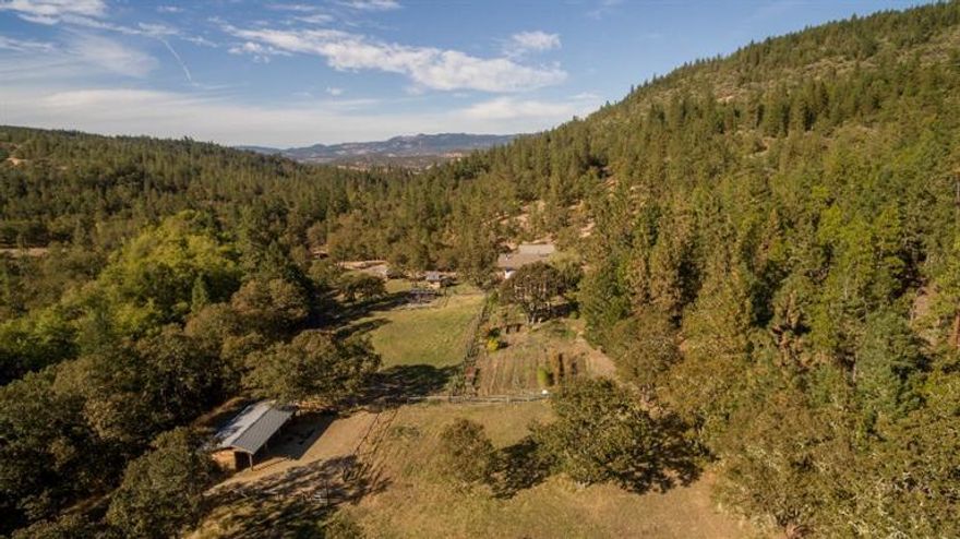 Custom built passive solar home on 159 pristine acres including 10+ irrigated & year round Lost Creek. This off grid home offers all the comforts you could want w/extensive solar panels, well insulated 2X6 construction & 22X30 heated shop w/220 power. Enjoy the warmth of natural wood throughout this incredible home w/clerestory windows, vaulted T&G ceilings, reclaimed wood beams & extensive custom built-ins. Slate floors throughout main level w/White Oak cabinets, wood cookstove & butlers pantry in the kitchen. Extensive 2nd flr loft features Fir floors, main bath boasts slate shower, soaking tub & Granite cntrs, 3rd bdrm offers sleeping loft w/built-in book shelves & secret closet. Skylights, solid wood interior doors, custom lighting, attached greenhouse, stucco exterior, seamless gutter system & tile roof. Fenced & cross fenced w/raised garden beds, fruit orchard, 4-bay equipment storage, 2-stall barn w/tack rm, marketable timber & adjacent to BLM land. Truly the Oregon dream home!