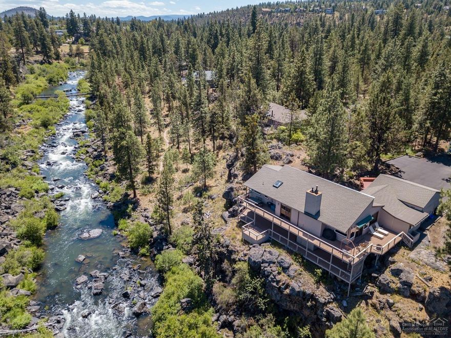A rare opportunity to own this riverfront home with spectacular views sitting on the scenic Deschutes River canyon. Nestled in a quiet, heavily treed .60 acre lot in a NW neighborhood just minutes from downtown. This beautiful home has had several updates and is very comfortable. With a floorplan capturing light and river views, two master suites, an open kitchen, large main floor, and sprawling decks that are perfect for entertaining! Access to trails and fishing right out your door.