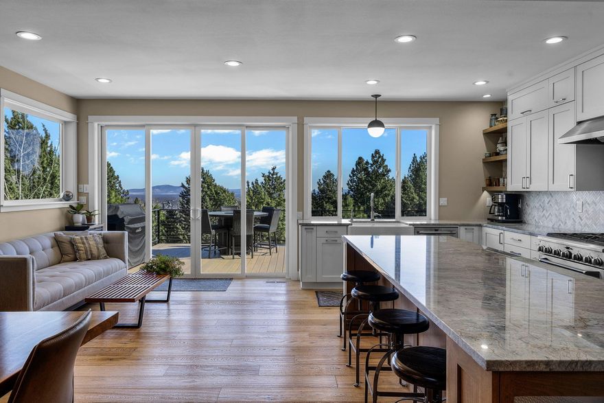 Perched on iconic Awbrey Butte, this timeless home blends modern and classic design. The great room features large windows with sweeping panoramic views to the north. A 2018 remodel, including a stunning addition, transformed the home into a masterpiece. The gourmet kitchen boasts Brazilian quartzite counters, custom cabinetry, large kitchen island, built-in dry bar, premium SS appliances, and walk-in pantry. Adjacent is a spacious 27'x 15' deck for outdoor entertaining. The main floor offers engineered white oak floors, a floor-to-ceiling fireplace, a designated office and a primary bedroom ensuite with dual walk-in closets and a soaking tub. The lower level which could also be used for multi-generational living has 3 bedrooms, media room, storage, and mudroom complete the space. The two-car garage includes an electric charger and overhead storage.  Located in Bend's desirable central west side, this home is perfect for those who enjoy an active lifestyle.
