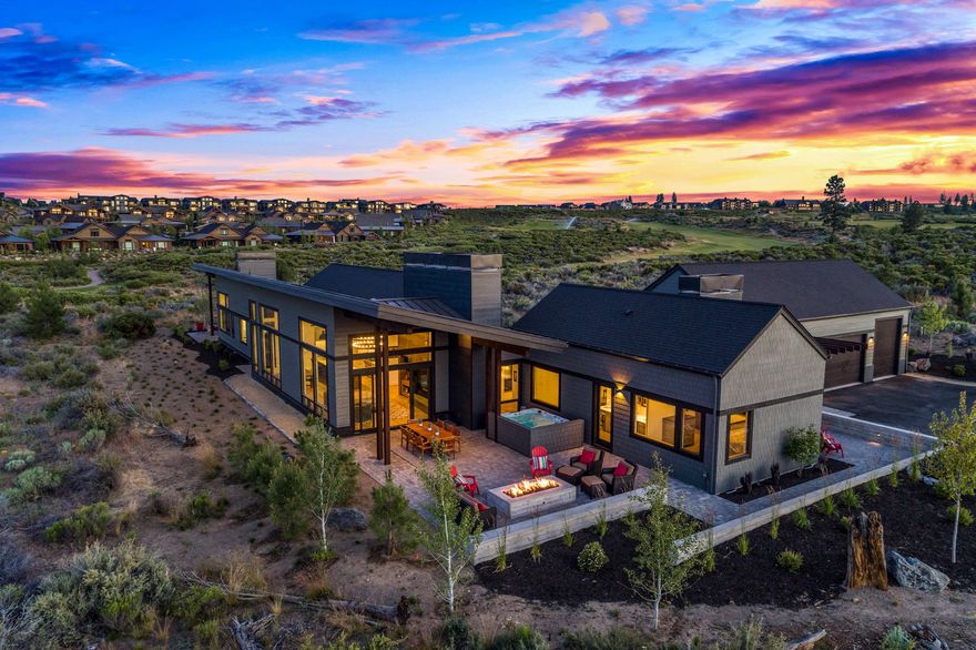 Stunning Mountain Modern single level home at end of one of Tetherow's most desired streets on famed 18th tee.  With nearly 4200 sf this home boasts high ceilings & huge windows for tons of natural light. The thoughtful design has 2 private & tranquil master suites-one with exterior entrance & kitchenette. 3 more en-suite bedrooms add to the privacy & easy livability of the home. There is a huge 3-car garage with 1 bay having an 11' door for Sprinter van or small RV. The gourmet, professional grade kitchen, 6' linear interior fireplace set in a gorgeous floor to ceiling cedar wall, 8' linear outdoor fire-pit, large patio, hot tub & appealing board form concrete walls make this home an entertainers dream. Additionally, there is a cozy home office/den with views and fireplace. The attention to detail in this home, including a powder bath with hidden secret door & Restoration Hardware vanities & lighting throughout, make this one of the most unique & beautiful homes within Tetherow.