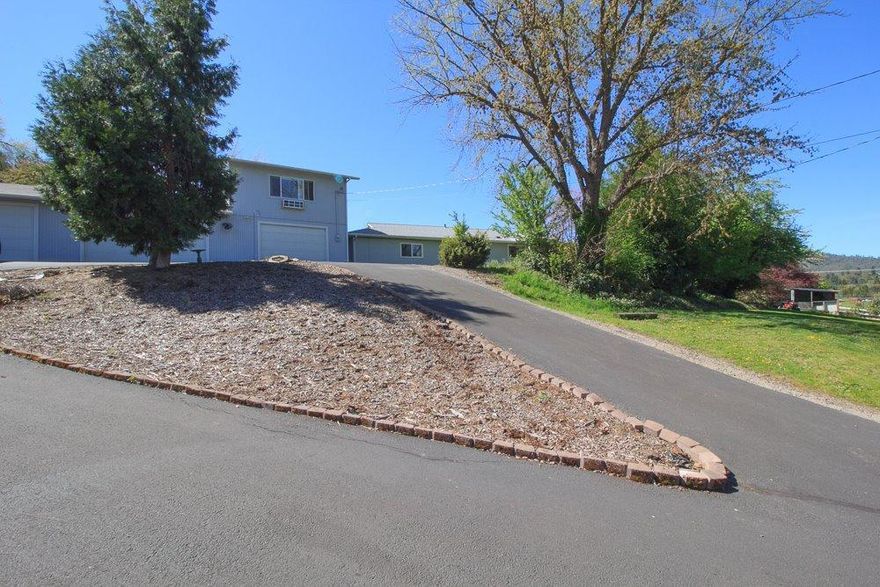 Southwest Medford home has lots of possibilities! This 3 bedroom, 2 bath gated ranch style home has 1705 square feet and is situated on just under an acre with Talent Irrigation! The home was built in 1956 and was remodeled in 1996 adding a huge master bedroom suite. The kitchen is light and bright with tile floors and counters, plus all appliances are included. Living room has access to the deck and side yard offering pastoral views. The second bedroom is currently being used as a den and has a slider to the back deck. Updates include new roof on main house in 2012, and detached garage roof in 2016, heat pump and windows in 2014 and water heater in 2016. Plus, the bonus is the detached garage which will fit about 6 cars and has a half bath! The middle bay is heated with propane and has a window a/c. Above the garage you will find guest quarters with a kitchenette and bathroom. Located in the desirable Griffin Creek and South Medford area schools. Close to town, with a countr