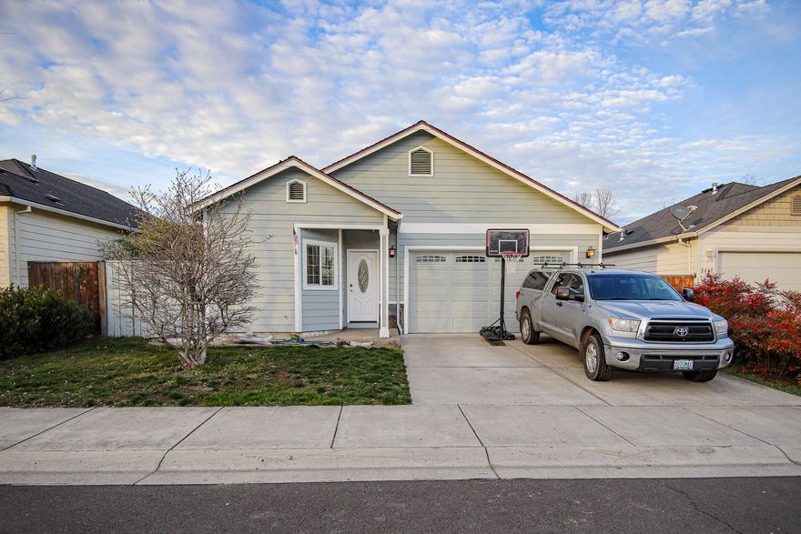 Come see this Contemporary single level home with vaulted ceilings, gas fireplace, and hardwood flooring through the main living area in a dynamite high end Central Point subdivision.  Big window in the kitchen with alder cabinets & pretty countertops.  Nice size master bedroom with slider out to the patio. Great floor plan plus finished double garage and more.