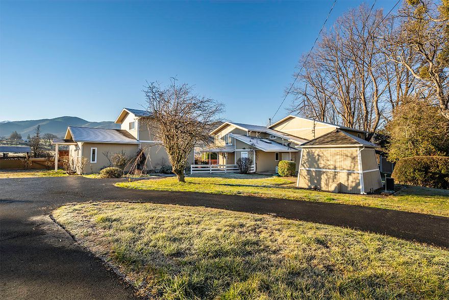 Fabulous rural Ashland view property on 10 level irrigated acres with mountain views. This property offers so much!  Enjoy close in Ashland living and your privacy too! Truly a great property with large main home, guest house, pool house, inground pool, 5 car garage and workshops. The main home is large with 3207 sq ft, freshly painted interior, expansive main living areas, soaring cathedral ceilings, hardwood flooring, chef's kitchen with dining bar, large dining room, 5 bedrooms and 2 ½ baths. Main living area overlooks the inground pool and entertainment decking. Separate pool house with full bath. Separate 2-story guest house is 1341 sq ft with open main living area, full bath, upper large bedroom with ½ bath and view balcony. There is a 5-car garage with 2 extra workrooms. Huge old barn and chicken coop.