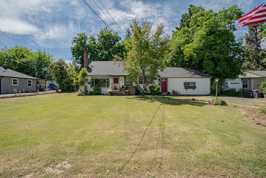 This country home sits on almost 1/2 acre between Jacksonville and Medford. Boasting 1,734 sq.ft. with three bedrooms, this home has original hardwood floors and a wonderful floor plan. Located on the end of a closed end country lane, you will have the country feel yet are close to town. As you walk in, you will notice the oak hardwood floors and natural light flowing in. The kitchen has plenty of cabinets and counter space. There is a very large, sunken living room that is great for entertaining or just relaxing. Outside, on this irrigated by MID property, you will find mature landscaping and park like setting. This property features so many and a variety of fruit trees and berries as well as garden area. There is a detached workshop to compliment this listing. This home is really a must see and is perfect for anyone wanting the country feel but needs to be close to town.