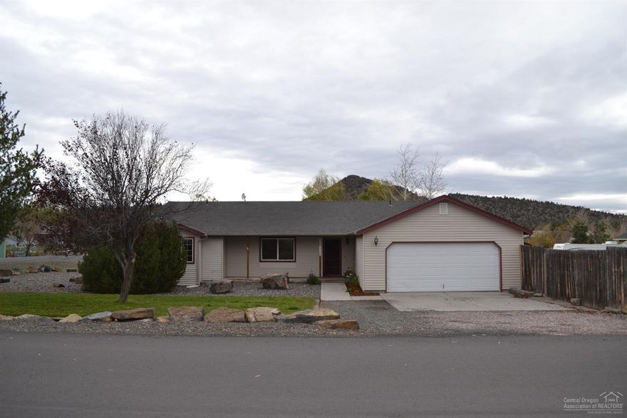 Large corner lot! This 3 bed 2 bath home is situated on a fenced 1/2 acre lot with double gated entry for ease of access. The home features all new carpet and paint inside, split floor plan, vaulted great room and propane stove to cozy up to on those chilly nights. The master bedroom has a large walk-in closet and a generous master bath and has private deck and access to back yard.