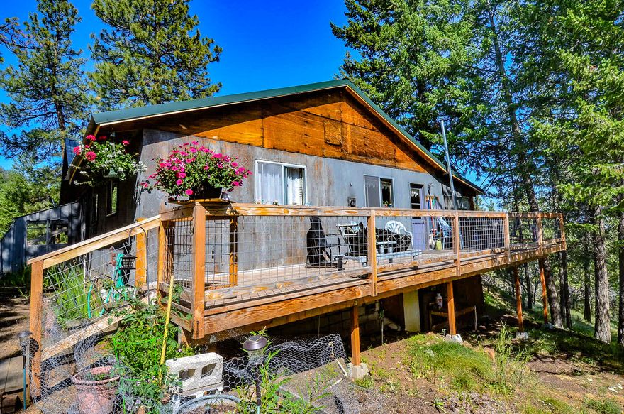 Escape to the tranquility of nature and find your perfect getaway at this off-grid cabin retreat. Nestled in the pines and mountains, this spacious cabin is the perfect place to escape the hustle and bustle of city life. With vaulted ceilings and large windows, you can enjoy the breathtaking views of the surrounding nature from the comfort of your living room. The kitchen is equipped with a propane range and refrigerator, while the bathroom boasts a tub shower insert. Step out onto the decks to take in your view and listen to the soothing sounds of the nearby creek. With 6.4 acres of land to explore and Dog Creek running through the corner of the property, there is plenty of outdoor space to enjoy. There is a bunkhouse, tool shed and open outbuilding to provide covered parking with a loft for storage. The solar system consists of three solar panels to power your 4 batteries. There is also a Honda generator that will be included in the sale.