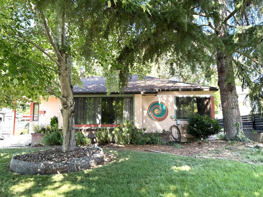 This adorable bungalow in Old East Medford is one you will not want to miss. It has classic features like the quaint entry, hardwood floors, charming fireplace and a large lot with trees for shade surrounded by other beautiful homes from the same period. The living room/dining area has an open feel that looks out to the front of the property.  This home has 2 bedrooms but if you need 3 bedrooms or an office, consider using the family room off the kitchen. Currently the family room opens to a large cedar deck in back with a pergola and it is perfect for entertaining or quiet hours with a good book. Please note that the lot is over 10,000 sq. so you have plenty of room for a garden in the 2 raised beds or dog run. Just off the back door is a 1-car carport with additional storage and a built-in grill.  These smaller homes in Old East Medford are hard to find so make an appointment today.