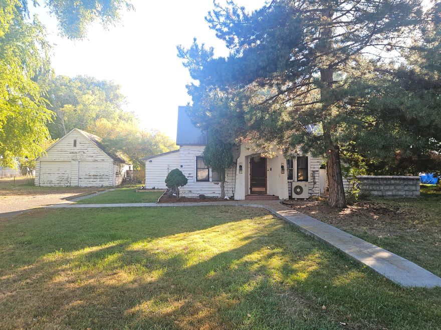 This 2 bedroom 1.5 bath home has 1,485 sq. ft. plus a partially finished attic with additional sq. ft. There is a dining area, laundry room and a room that could be used for an office. The living room has a fireplace and nice built-in cabinets. Property is located in the suburbs! Nice sized lot, almost an acre, .94 acre. The home has a metal roof. Detached 2 car garage. KID Irrigation.