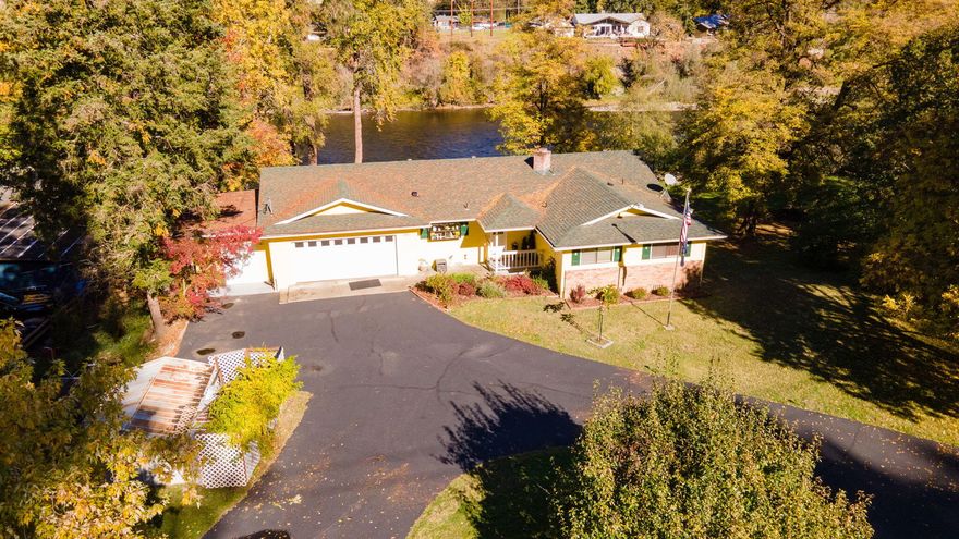 Beautifully maintained riverfront home on over three-quarters of an acre with direct access to the Rogue River. This 1,522 sq ft home has been thoughtfully updated with new flooring throughout and a fresh exterior paint job. The spacious deck overlooks the river and features a built-in hot tub, perfect for relaxing, entertaining, or simply taking in the peaceful views. The property includes an oversized two-car garage with a dedicated shop area, plus additional large carports ideal for boats, RVs, or extra storage. Mature landscaping, open yard space, and easy river access make this property a rare find. Move-in ready and very well cared for, offering the perfect blend of comfort, functionality, and the sought-after Rogue River lifestyle, all just minutes from town conveniences.