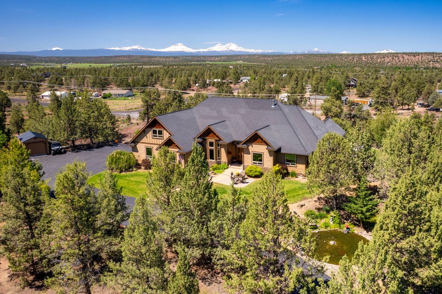 Discover unparalleled luxury in this breathtaking custom-built home on the bluff w/ spectacular Cascade Mountain views from Bachelor to Hood. Step inside the mahogany doors to soaring 28' ceilings adorned w/ exposed beams & complimented by floor to ceiling windows & hickory hardwood floors. The expansive open kitchen is a chef's dream, featuring granite countertops, double oven & wet bar. The primary bedroom boasts a vaulted ceiling, his & hers closets, and a spa-like ensuite with a tile shower + soaking tub w/mountain views. Above the garage, a spacious bonus room offers expanded living space. Outside, a tri-level paver patio w/ firepit invites you to enjoy the stunning surroundings, while a 17' swim spa provides year-round relaxation. Attractive black wrought iron fencing encloses the rear yard. Property also includes a detached ADU w/ ductless air, perfect for guests or additional living space. Experience the perfect blend of elegance and comfort in this Central Oregon paradise.