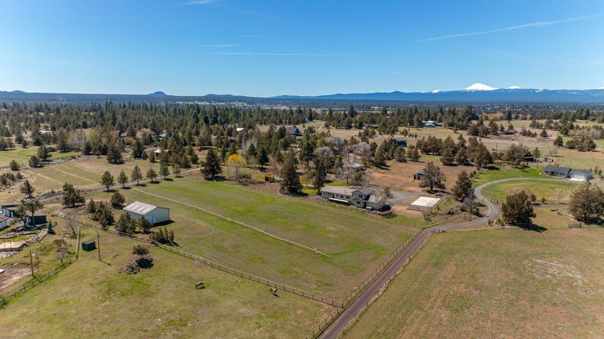 Tucked back off of Ward Road in Southeast Bend, this home sits in one of the area's most desirable small acreage locations. Set on over five acres with 4.3 acres of water rights, this is the perfect place to pursue your hobby farm or master gardener dreams. A recent remodel of the light filled 2,266 square foot home includes new light fixtures, hard surface counters, country-living perfect vinyl plank flooring & a truly dialed primary bathroom. Whatever your morning routine, you won't want to miss the incredible sunrises that douse this property with a golden hue at dawn. Add your own touches to the property that includes a pipe fenced livestock paddock, chicken coop and shop/pole barn with two large garage doors that make it perfect for storing farm equipment, hay and all of the toys. Along with its tranquil setting, this home is also perfect for entertaining and endless activities with a brand new firepit & sport court, perfect for making the most of our amazing Central Oregon days.