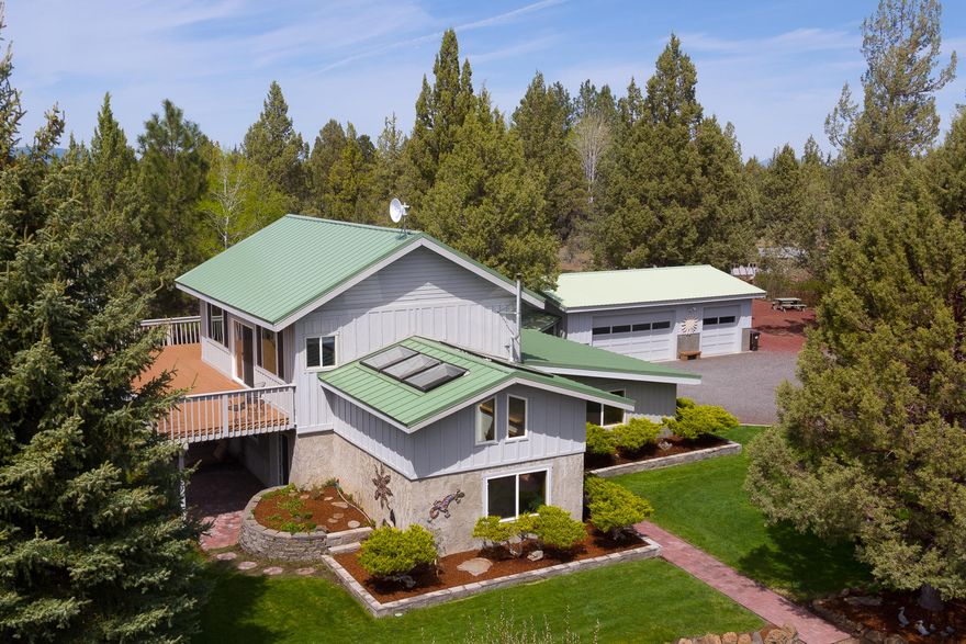 Rare opportunity to own a peaceful 5 acre retreat centrally located between Bend and Sisters. This quality built, well-insulated timber framed home is full of character and charm. Vaulted ceilings and skylights offer natural light. Enjoy massive Cascade views everywhere, especially from the relaxing en-suite master bedroom featuring a sitting area and a viewing deck. Enjoy entertaining on either of the two lower decks, one with an outdoor sitting bar and one with a pizza oven/fireplace.  This home sits within a unique mature juniper grove with a perennial flower wonderland below.  Gardens everywhere, indoors and out. This is a garden enthusiast's dream property! Situated close to public land with a 3 car garage, large shop, a greenhouse and raised beds. There is plenty of room for toys, horses or whatever your heart desires.