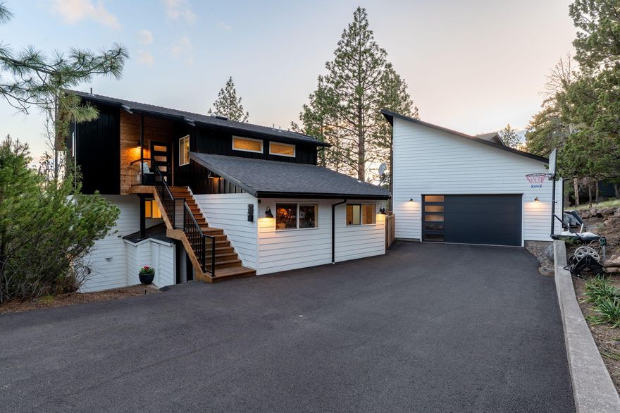 Views, Views, Views! Perched in Bend's coveted West Hills neighborhood, this exceptional home offers sweeping Cascade Mountain views, glowing sunsets & ever-changing skies. Enjoy southern exposure & a nearly flat, oversized driveway perfect for RV parking or extra vehicles. Inside, vaulted ceilings and an open layout create a warm, airy feel. The light-filled kitchen anchors the main level and flows into spacious living and dining areas. The luxurious primary suite features a large tiled walk-in shower + generous closet. Additional 2 bedrooms & 4  beautifully updated bathrooms offer comfort & flexibility. A fully finished guest quarters provide private space for extended stays or income potential. Outdoors, enjoy upper and lower Trex decks, hot tub, and fire pit under the stars. Extras include paid-off solar panels, raised garden beds, detached 832SF garage/shop w/ unfinished space above offering room to grow. A rare West Hills gem blending privacy, function & the best of Bend living!
