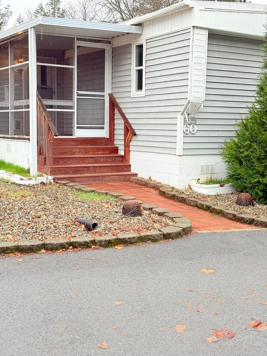 Delightful  2 bedroom 2 Bath Home located in the 55+ River Valley Village MFH park. Close to town and amenities. The home is classified a single wide home but has the bump out to expand the living space giving it a more open spacious feel. Newer flooring, New Hot water heater (2025);Newer certified wood stove with some extra wood on porch;  just in time for those chilly nights.  Bedrooms are a split floor plan with living space, dining and kitchen in between  Two  bathrooms, one with tub/shower combo, single sink. The other bathroom  is shower only with dual sinks.   Home has enclosed front and back porch for your year round enjoyment. Sale also includes all appliances, storage shed and covered carport. Park Approval is required. One of the more affordable 55+ parks. Come check it out.