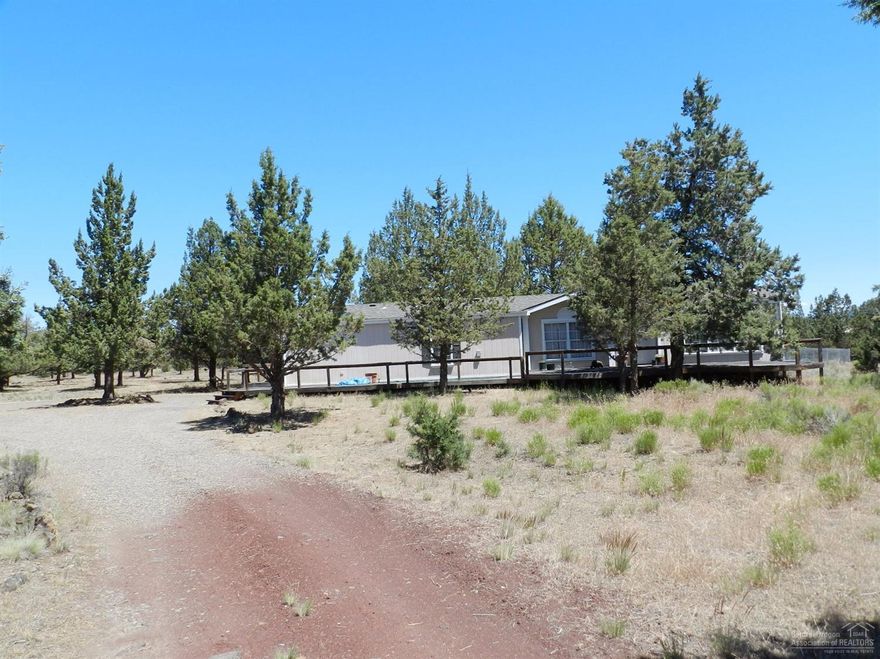 Spacious one owner manufactured home located on the Canyon Rim just inside Crooked River Ranch for easy commuting. Wrap around decking makes this home an outdoor delight for entertaining and enjoying area wildlife. Home offers a large master suite with soaking tub and shower, separate family room, living room and formal dining area as well as a large country kitchen with breakfast area, center island and rear deck access. There is newer carpeting in living areas, but mostly original fixtures and finishes.