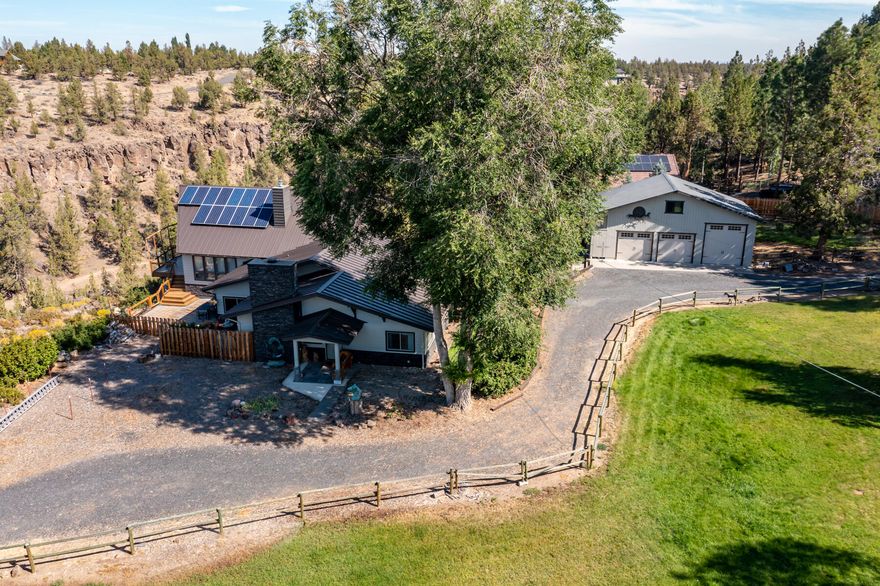 Picturesque property in Tumalo on the rim above the Deschutes with stunning mtn & river views! Peaceful 1.85 acres w/ 2,879 sf home, carport & separate garage, RV or workshop w/ large storage loft. Expansive windows give this home lots of light & great views. Large deck & paver patio are perfect for entertaining. Great room w/ vaulted tongue & groove wood ceilings shows off a custom designed slate 2-sided fireplace which soars from floor to ceiling. Large open kitchen includes custom cabinets, quartz countertops w/ plenty of storage. Carport allows for quick access to the utility/laundry room w/ lots of storage & is located just off the kitchen. Private primary suite with vaulted tongue & groove wood ceiling, large windows, huge walk-in closet & separate access to deck. Primary bath has a tiled walk-in shower, jetted tub & dual lav vanity. Loft is used as office & sleeping area. Solar photovoltaic system provides for low electric costs. Newer roof & outside paint. Well & irrigation.