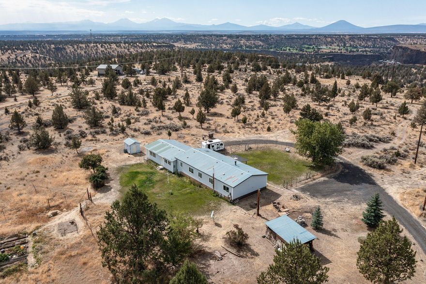 Don't miss your opportunity to own an expansive 40 acres of dream property in the Central Oregon grasslands w/theCascades as a backdrop. Nestled off the main road, this property offers beautiful mountain views & a well maintained 3 bed, 2 bath manufactured home. 2 kitchens & an open plan make it great for entertaining. Main living area boasts vaulted ceilings, ceiling fan, rustic farmhouse appeal & woodburning stove. Kitchen has tons of cabinetry & counter space w/skylight, appliances & built-in eating area. Formal dining room is located btw kitchen & main living area w/secondary canning kitchen just off garage w/storage room. Three well sized bedrooms,  two full baths & laundry room. Two car attached garage & plenty of space for your RV & toys! Fenced area w/grass in rear + deck. Located less than 12 miles from Redmond, 30 miles from Bend, minutes to Lake Billy Chinook & Smith Rock State Park. Enjoy all that Central Oregon has to offer! Live, work, play & build your dream home here!