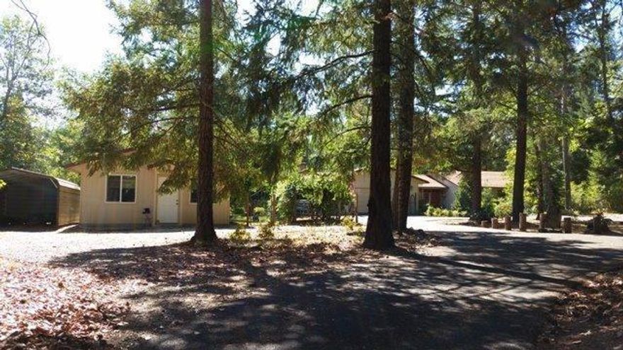 This home has a separate legal guest house too! It's less than 6 miles from the Redwood Hwy. (Hwy 199) and close to the famed Findley Bend where you can find some of the best fishing on the Rogue. Shan Creek provides recorded irrigation rights! Make yourself comfortable in the formal living room in front of your wood burning fireplace, taking in the view of the forest. Or enjoy the views from the cozy family room in front of the wood burning stove. Custom cabinets set off the kitchen and the formal dining room is just steps away from a deck at the back of the house facing the creek. The master bedroom has a deck as well as a good sized master bath. Wood flooring can be found throughout all bedrooms and hallway. The guest house has its own kitchen with a comfortable living room and separate bedroom. Attached two car garage, RV parking, 2 metal car ports for additional cars or toys. Enjoy the manicured yard with producing fruit trees and a grape arbor while you just spend time relaxing.