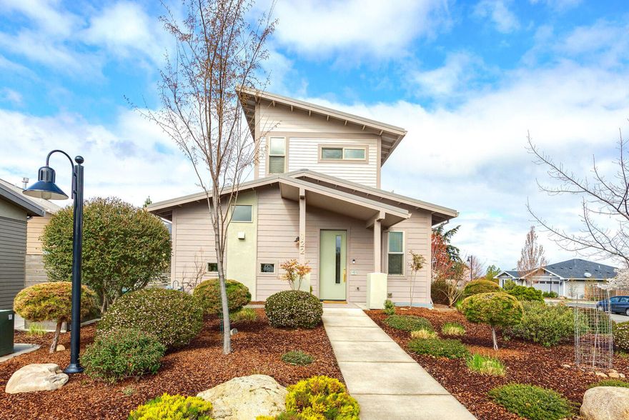 Beautifully updated, move-in-ready home in sought after Verde Village! Built by Suncrest and professionally remodeled by Meadowlark Interiors in 2023, this is the largest floor plan in the cottage phase at almost 1500 SF. The main level features a gorgeous kitchen with freshly painted cabinets, Rejuvenation hardware, a new Bosch dishwasher and granite countertops. The living room has a gas fireplace and views of the landscaped patio. The primary suite is on the main level and features a spa-like remodeled shower, vanity and mirror. Laundry and half bath are also on this level. Upstairs you'll be captivated by the endless natural light and mountain views in the open landing, spacious enough for an office or entertainment room. Another updated, full bath and bedroom grace the upper level. The home's exterior is freshly painted with a one-car garage nearby. Earth Advantage construction with metal roof, mini-splits and owned 4.25 kW solar array for net zero electrical. Such a rare find!