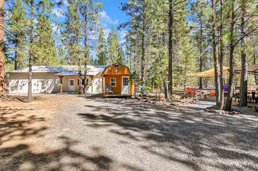 Amazing opportunity to create your own paradise. Come home to tranquility in Ponderosa Pines. It is a home owners community that is peaceful, secluded, & well maintained w/road maintenance & plowing in winter. This lot was completely fenced in July 2021 w/3 gates. The original 960 Sq Ft shop was built in 1986 & 960 more Sq Ft were added on in 1996. The back of shop is an unpermitted partially framed living space of approx. 960 Sq Ft. A new 10 x 20 insulated shed added for home office space w/power & fiber optic hookup for fast internet. The lot is treed, w/gravel drives, septic, electric, water, & fiber optic cable. The lot is professionally cleared of needles & debris in May 2021. Many special areas for firepit, dining, games, hammocks, relaxation. Let pets roam free! This property is in the backyard of all Central Oregon recreation. Potentially available for $25,000  is a 2020 Forest River Wildwood Travel Trailer, like new. Can be hooked up to power & septic on the lot. CASH ONLY