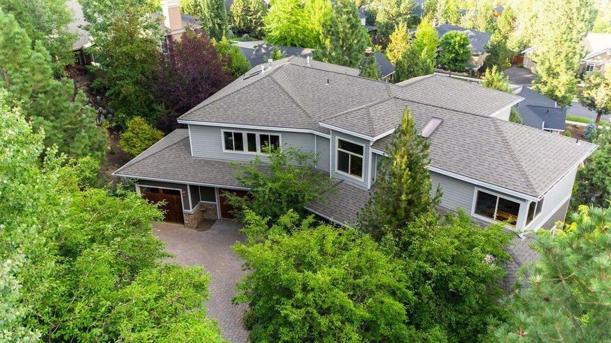 Life is sweet when surrounded by birds, views, sunrises, and privacy.  You can recline in the sunroom with the soothing sounds of the water feature, tinker in the triple garage with 50 amp and 30 amp plugs and slumber in the main level owner's suite.  All of this is available in this exquisite custom home, impressively designed and constructed with stunning use of wood, stone, tile and Hubbardton Forge lighting.  From the Myrtlewood flooring, knotty alder cabinetry, and wood wrapped beams to the circular flow of the living spaces, the second floor junior suite, spacious bedrooms, and vaulted ceiling, you will love the thoughtful crafting, finish quality and attention to detail.  Enjoy valley views, a new heated driveway, covered mahogany front porch, two mahogany balconies,  a gigantic bonus room and office nook all adding to the perfection of this home.  The under house storage is expansive, the landscaping is easy care, the privacy is fantastic and the roof was replaced in 2021.