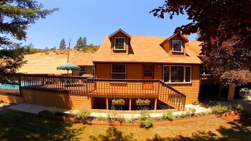 Wonderful chalet home with warm wood everywhere you look, all on 5 usable private acres. The living room has a fantastic Aspen peaked ceiling with windows top to bottom and lots of beautiful, warm wood, and a brick fireplace. The kitchen is beautifully upgraded with new wood cabinets and granite counters, stainless appliances and tile backsplash. Master suite with a sitting room on the main floor as well as an amazing master suite downstairs complete with sauna and door to the hot tub. Upstairs you will find two bedrooms with dormers and a full bathroom. Lots of built in shelving and storage everywhere. Outside you will find a large deck, swimming pool, sand volleyball court, and a fantastic, fenced garden with raised beds. When last tested, the well was 5 gpm. This is a wonderful home for entertaining, raising a family, or peaceful, country living.