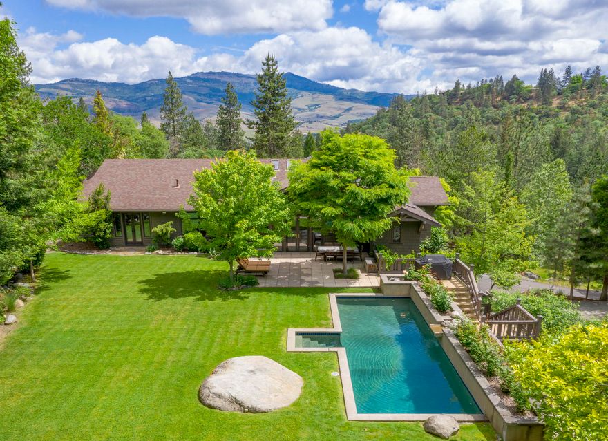 Estate on 3.18 secluded acres in park-like setting, across from 93 acre Lithia Park & blocks to Ashland's downtown plaza. 5720 SF Green & Green style craftsman built in 1992, w/ kitchen & 1.5 baths recently remodeled. Main level features two bedrooms; two offices; informal & formal dining; family room; & great room w/ view of Grizzly Peak. Lower level has 3 bedrooms, laundry & full guest quarters w/ kitchen. Lush private yard w/ solar-heated pool, pond, & waterfalls. Direct access to hiking & running trails; less than 5-minute walk to tennis courts. Includes separate 676 SF guest cottage w/ garage. Rare opportunity to own one of Ashland's most stunning estates.