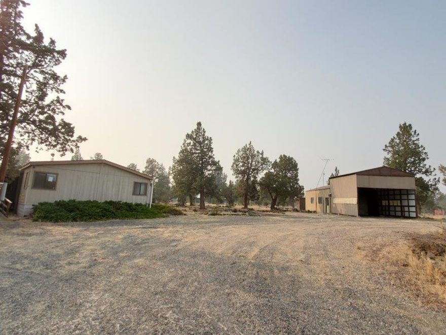 2 1/2 Acres! Lots of room here and plenty of parking! Nice level lot with circle driveway and on a paved road. Manufactured home features a bonus room, kitchen has an island, built in hutches and is open to the living room. Dining area also has a built in hutch. No shortage for storage with the detached Garage/shop and oversized carport plus additional outbuildings.