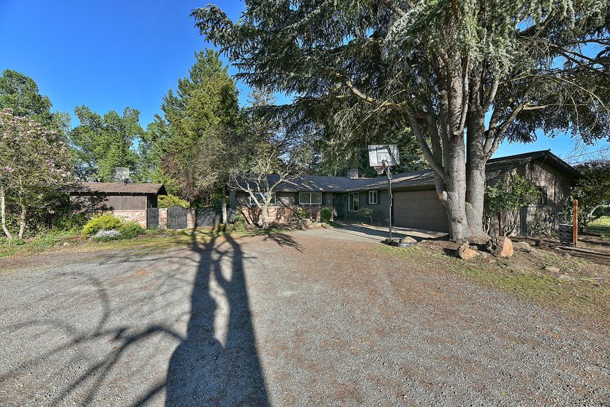 Rare opportunity to own a very well maintained partial updated home conveniently located on close to 2 acres on two separate tax lots.  Tucked away from the main road you are in your own sanctuary with park-like landscaping, mature trees, pool, approximately 20' x 40' shop, & additional EFU zoned vacant lot! Boasting 1752 sq ft, 3 bed, 2 bath this home has a cozy charm to it. Newer laminate flooring throughout, cozy wood fireplace and large picture windows for an abundance of natural light fill the house. Large Primary bedroom w/ dual sinks, tub shower combo & large walk-in closet. Ample sized guest rooms & bath. The interior has some updates but room for your own twist as well. Outside is were this property shines; peaceful serene yard, shop, hot tub, pool, pool house, RV Parking, many mature tall trees for privacy, the list goes on! Being close to parks shops & more this one won't last long, call today!