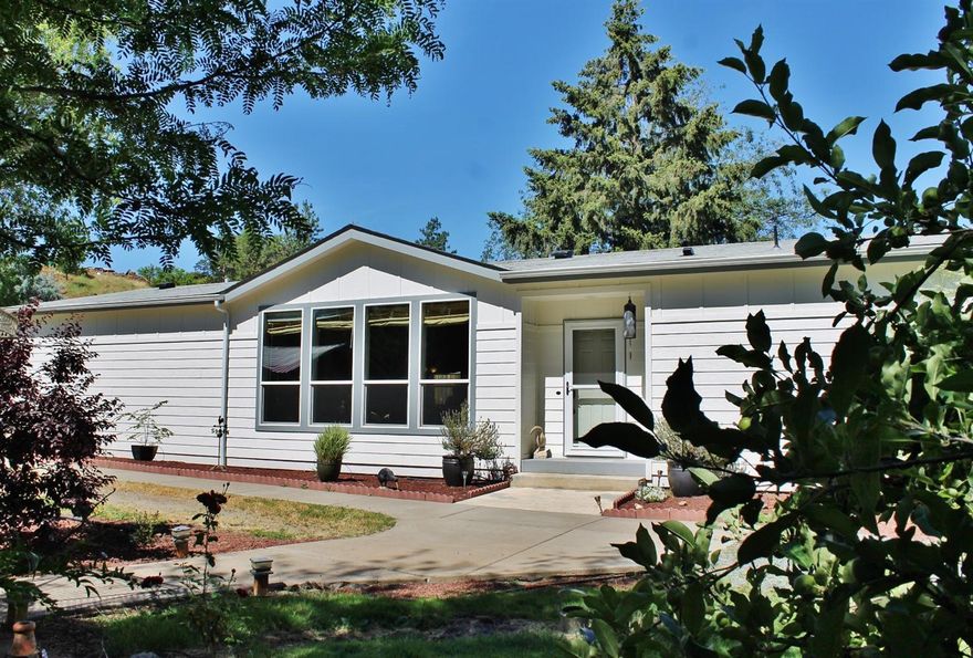 Wonderful country home on .54ac w/oversized attached garage, additional shop and outbuildings, irrigation through Medford Irrigation District, Medford City water and Rogue Valley Sewer Service. 2013 built Palm Harbor double wide with foundation on flat usable acreage in the Griffin Creek area. Minutes to Jacksonville and vineyard country. Beautiful garden and grounds with mature landscape, trees and shrubbery. 3 bedrooms, 2 large bathrooms with island kitchen, upgraded cabinetry and storage space throughout. Large open living and dining area, his and hers walk through closet w/double sinks in master. Good sized mud room off covered patio. This may be a terrific opportunity for low down FHA, fist time Buyer or anyone who wants some room to breathe in a country setting close to conveniences, school and parks.