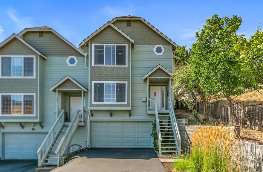 Updated end-unit condo with lovely mountain views and abundant natural light — steps from community gardens, picnic tables, walking paths, and playgrounds of dog-friendly Scenic Park! Solid oak hardwood entry, living room with mounted flat screen and sound bar, gas fireplace, window bench, and half bath with washer and dryer. Kitchen with new stainless GE range oven and counter-depth Samsung refrigerator; dining area with sliding glass door to fully-fenced private backyard. Vaulted primary suite with walk-in closet and ull ensuite bath with double vanity and tub shower, two guest bedrooms with closets, and full guest bath with tub shower. All new ceiling fans, carpets, and large-format waterproof vinyl tile floors throughout. Interior stair to lower-level garage and large finished bonus room. Nine-unit association covers all exterior maintenance including roof, gutters, siding, paint, stairs, annual window cleaning, fencing, parking, and common area landscaping. Inquire for details!