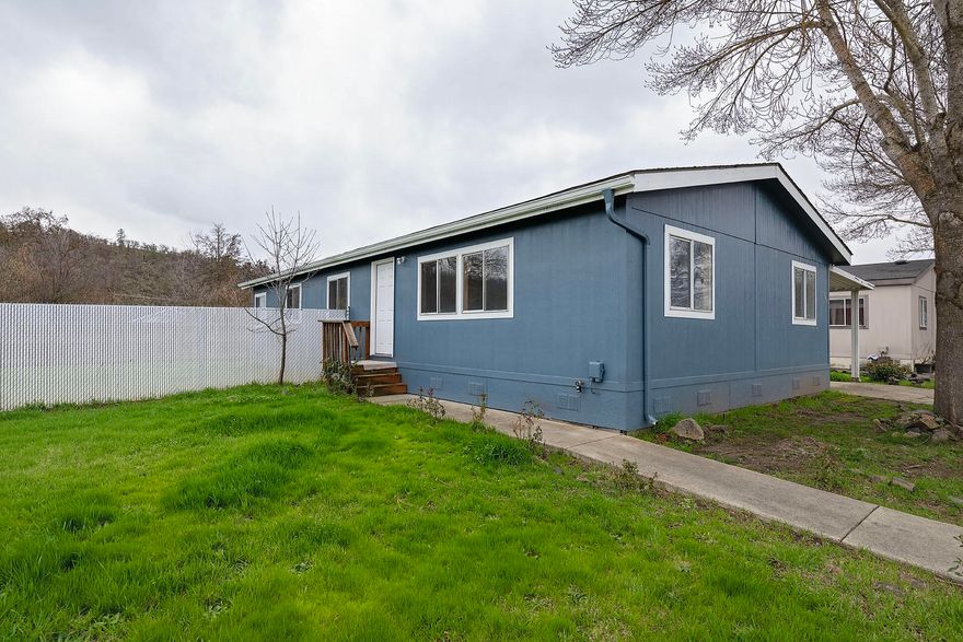 Welcome to your new home in the heart of Eagle Point where comfort meets convenience in this beautiful manufactured home situated in an all-age park. This residence is a true gem, perfectly positioned on a corner lot, ensuring privacy with only neighbors on one side and featuring a vast backyard for your enjoyment.
Step inside and be greeted by the fresh allure of brand new flooring that spans the entire home. The entire interior has been tastefully adorned with a fresh coat of paint, creating a bright and inviting atmosphere throughout. The kitchen is a highlight, boasting appliances, including a refrigerator, and providing the perfect space for culinary adventures. As a bonus, this home comes with an attached carport, offering ample parking space for you and your guests. The storage shed provides additional convenience, allowing you to keep things organized without compromising on space within the home.