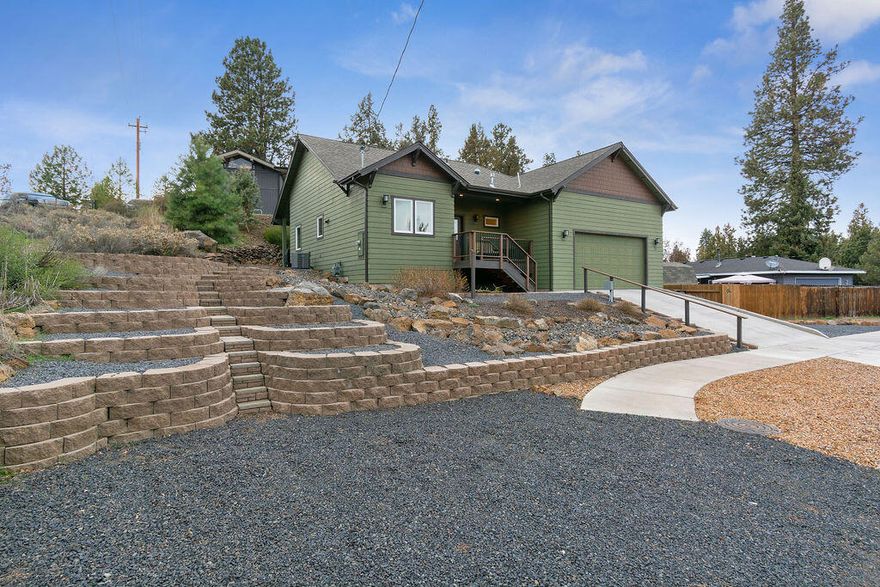 Experience the epitome of craftsmanship & convenience in this immaculate single-level home nestled on a tranquil dead-end street near Pilot Butte. Beyond its charming covered porch lies a meticulously designed open floor plan, adorned with hardwood floors and bathed in natural light. Discover culinary bliss in the gourmet kitchen boasting quartz counters, stainless appliances & a sprawling walk-in pantry. The vaulted great room beckons relaxation with a cozy gas fireplace and elegant built-ins. Work-from-home seamlessly in the adjacent office, while the primary retreat offers unrivaled solace with exterior access, a luxurious travertine porcelain shower & heated floor near sinks. Other highlights include a craft/bonus room, generous below home secure storage, heated driveway for winter ease & rear patio wired for a hot tub. Embrace low-maintenance living, complete with side gravel parking for small RVs. Your dream home awaits - seize this opportunity for unparalleled comfort.