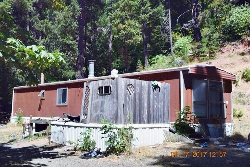 5.18 acres in the tall timber with homesite developed, well and septic in. Mobile holds the dwelling site and mobile and shop need large amount of TLC. Quiet location just outside of Selma. This is a cash only sale with NO Owner Terms.