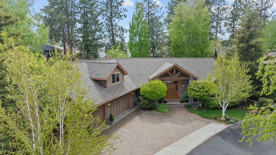 Welcome home to this custom Schumacher residence tucked behind the private gates of Charleswood Ln in SW Bend's RiverRim community. Single-level living with the exception of a large bonus/flex space above the oversized 3-car garage. The central great room boasts a floor-to-ceiling stone fireplace, vaulted wood ceiling with custom beams, and large SW-facing windows to take in the fenced, landscaped, and private backyard. The great room adjoins the dining area, which flows into the spacious kitchen built around the large island with granite countertops and luxury stainless appliances. The private office could serve as a fourth bedroom. The south wing features the primary suite, with heated bathroom floors, soaking tub & full-tile shower. The north wing hosts the secondary ensuite and cozy guest room. Over $60K in updates completed in 2015 by Neil Kelly Design and new roof in 2024.