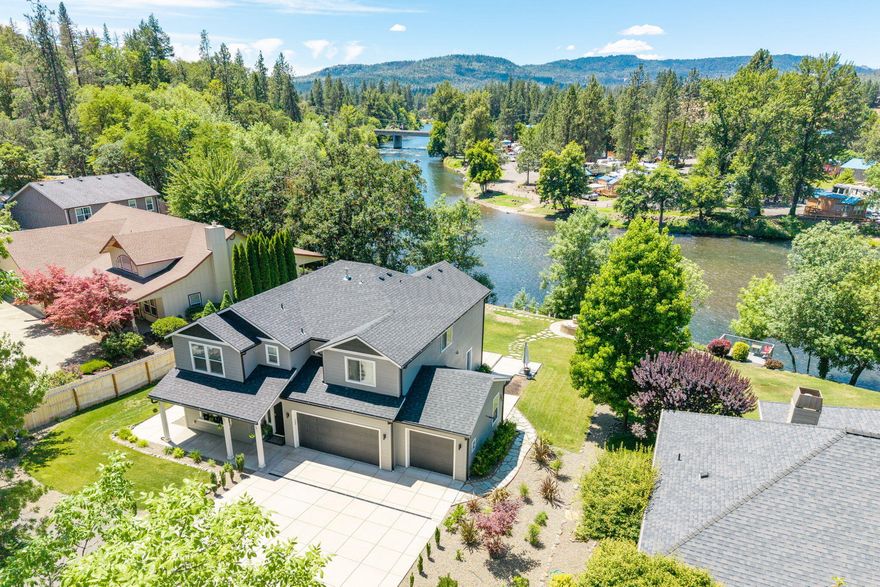 Better than new and perhaps the best Rogue Riverfront value available in Southern Oregon today, this rare offering is absolutely packed with hard-to-find features, various usable spaces inside and out, and situated on a gorgeous stretch of the Rogue. Custom built in 2021, the home offers 5 bedrooms, one of which functions well as an office or den, 2 primary suites, 3.5 baths, 2,992 SF, an island kitchen, pantry, mud room and a 3 car garage. Abundant windows allow for exceptional natural light and gorgeous views throughout. Outside you'll enjoy expansive patios including a covered patio with electronic shades and 2 heaters, flagstone walks and sitting areas, and a fully irrigated .41 acre lot with a level, usable yard. It all overlooks the river with a view of the bridge providing a unique architectural backdrop. Truly a one-of-a-kind package with too many extras to list here. Inquire for more details. Listing agent is related to seller.