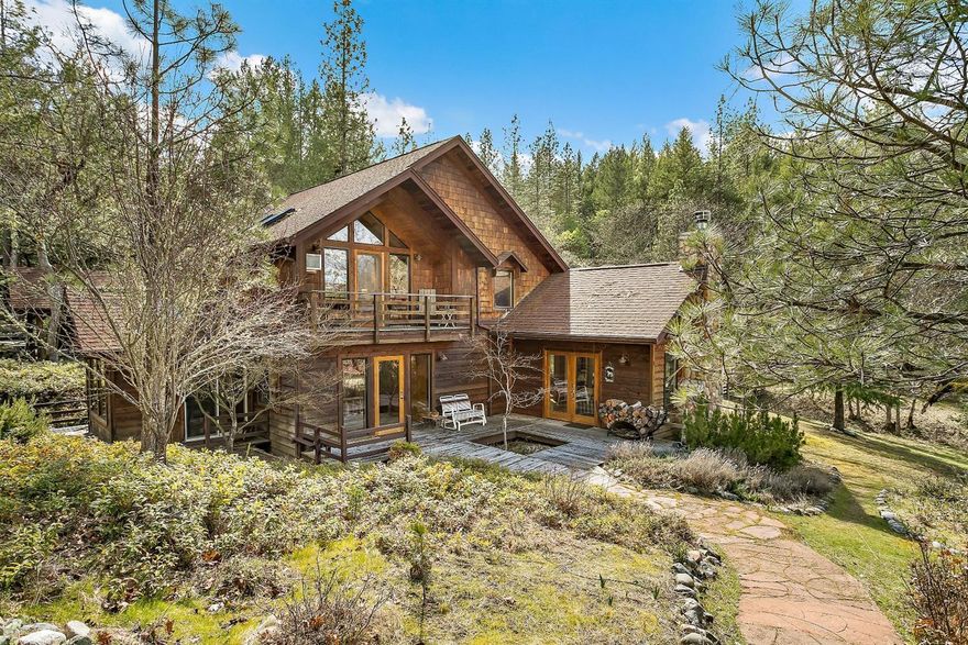 Lodge-style home sits on 20 gorgeous, private & quiet acres w/horse set-up & BLM access all less than 15 miles to historic town of Jacksonville. Transom windows soar to exposed beam vaulted great room ceilings with stunning private views of forested setting! Remodeled kitchen w/granite island, quartz counters & newer appliances. Wood floors lead to both picturesque family room w/river rock fireplace & more views from formal dining room. Enjoy expanded living under huge oak tree canopies over huge deck w/eating bar & newer spa. Vaulted master w/private deck, skylights & remodeled bath w/dual sink granite counter vanities & tile floor. 864 sq ft 3-stall barn w/lg tack room w/fenced lg corral & compacted area for round pen w/easy access to BLM. Fenced organic raised bed garden & shed, arbor patio along seasonal creek/pond, meditation shelter. Garage w/shop area. Office loft. Guest bath w/jetted tub, heated floor & oversized rock shower. All information deemed reliable, but not guaranteed.